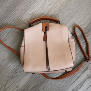 Pinkinsh- brown leather like womens satchel with brown handles. Lots of zippers